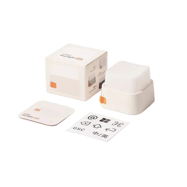 Packaging display showing the keylight mini keyboard light with its box, a small accessory piece, and instruction manual on a clean off-white background. Text at the top reads 'PACKAGING DISPLAY' and the keylight mini logo appears at the bottom right.