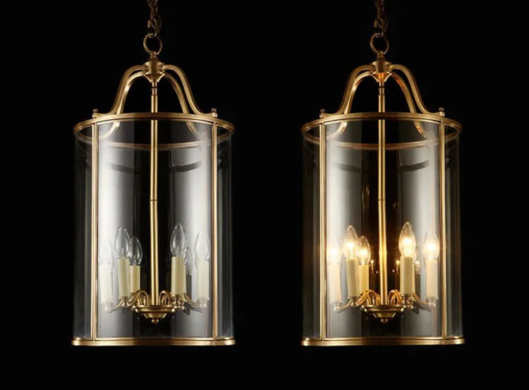 Two gold pendant lights with clear glass shades on a black background