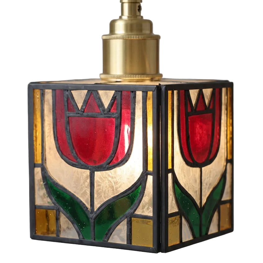 A vintage-style stained glass pendant light featuring two red tulips with green leaves inside a square frame, with a brass-colored metal neck at the top, shown against a solid gray background.