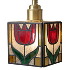 A vintage-style stained glass pendant light featuring two red tulips with green leaves inside a square frame, with a brass-colored metal neck at the top, shown against a solid gray background.