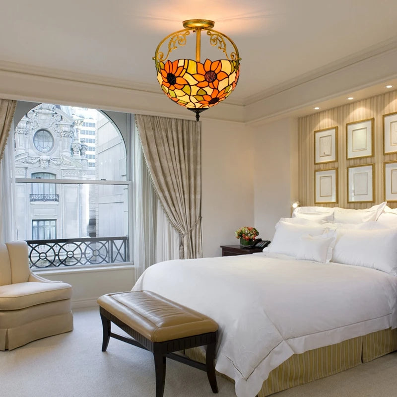 Luxurious bedroom with a stained glass ceiling light fixture, bed, and armchair.