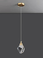 Pendant light with crystal shade and gold fixture on a gray background