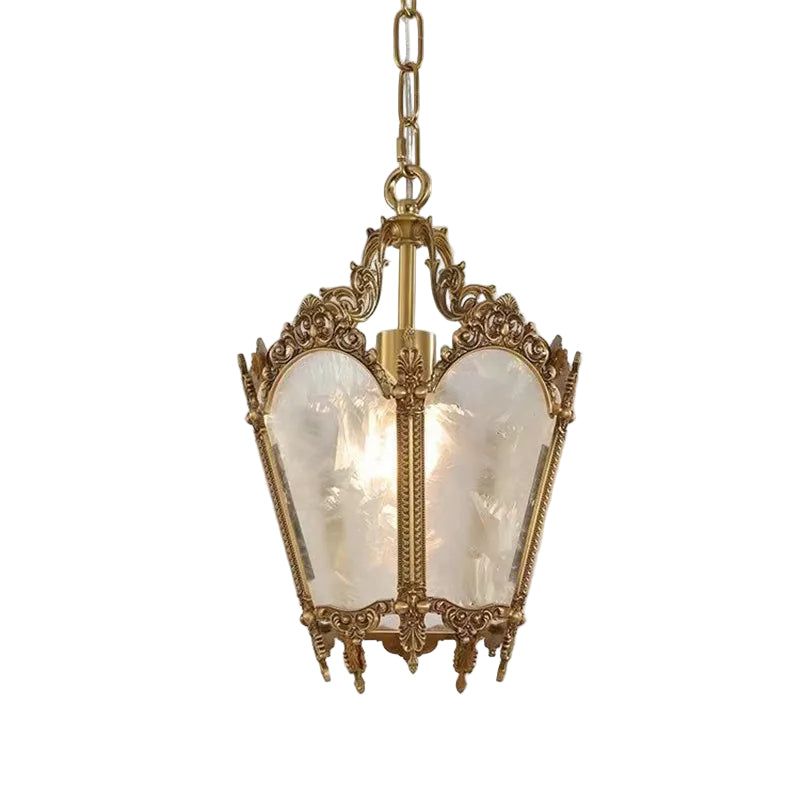 Decorative pendant light with ornate gold fixture on a white background