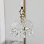 Small crystal chandelier with decorative elements on a plain background