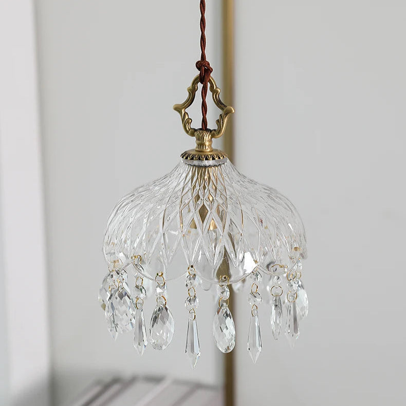 Small crystal chandelier with decorative elements on a plain background