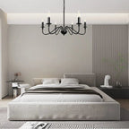 Modern bedroom with gray bed and chandelier, transitioning to a dining area with white table and chairs.