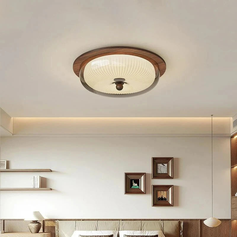 Ceiling light fixture in a modern interior setting with wall decorations.