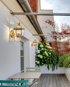 Outdoor patio with table, chairs, and hanging plants under a white pergola.
